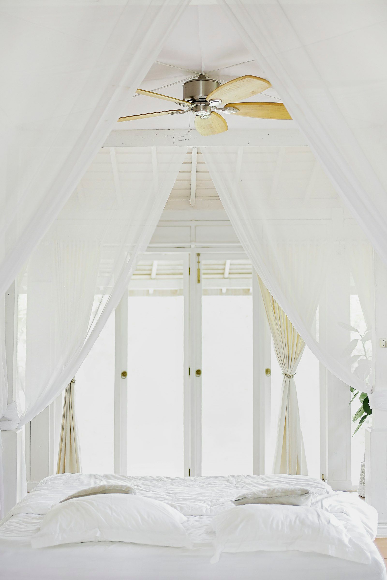 White linen curtains moving in front of open glass doors