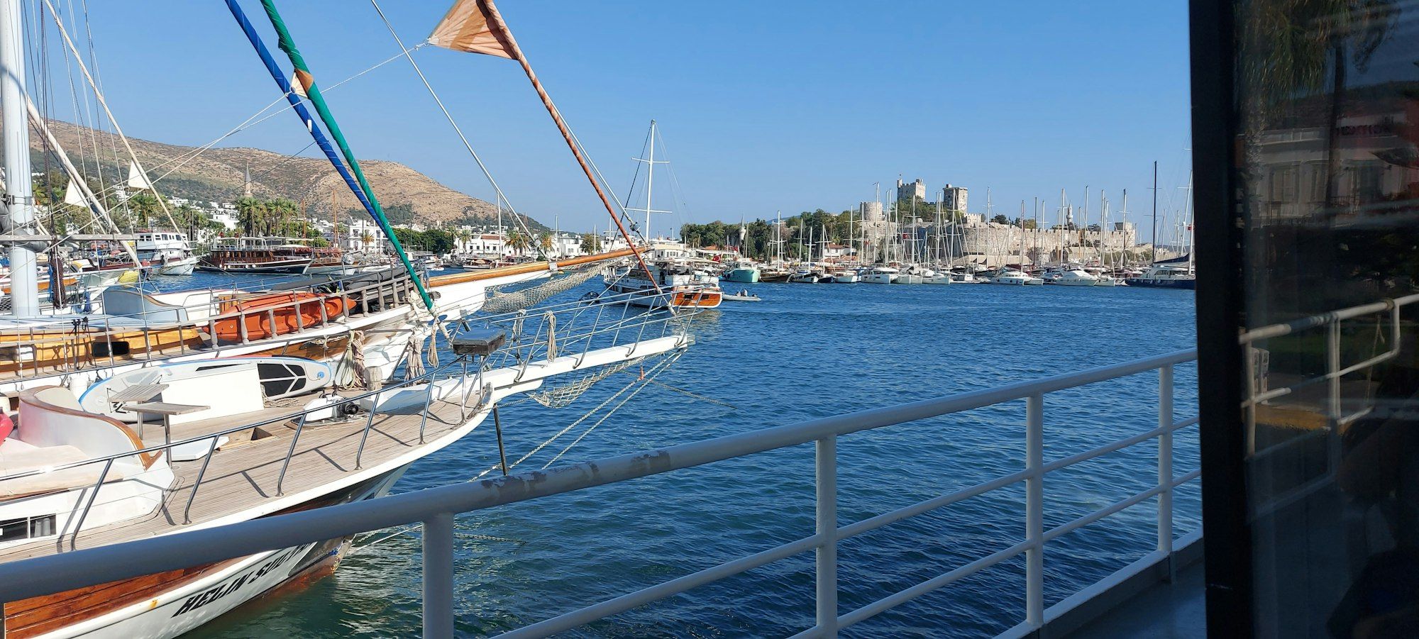 Sailing boats moored in Bodrum harbour with the stone castle in the distance